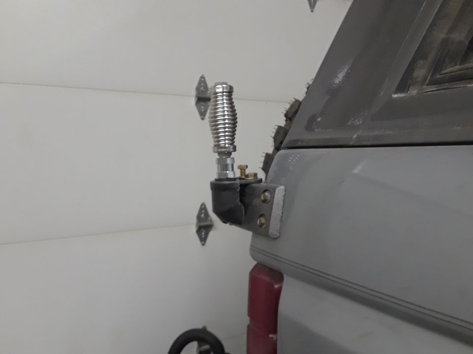 Close-up of a custom antenna mount on a gray truck cap.