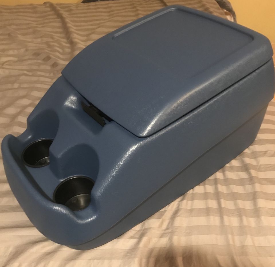 Blue plastic center console with two cup holders and a hinged lid.