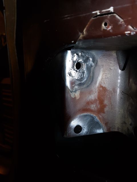 1978 Ford Bronco - A close-up view shows a threaded hole with surrounding weld marks on a metal surface, likely part of a vehicle's chassis or frame.