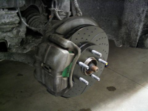 1996 Mercury Sable - Close-up view of a vehicle's brake caliper and a drilled rotor, likely part of a brake upgrade.
