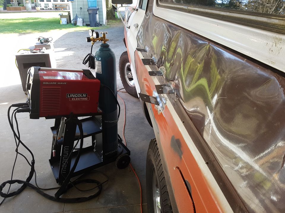 Welding equipment next to a damaged classic vehicle.