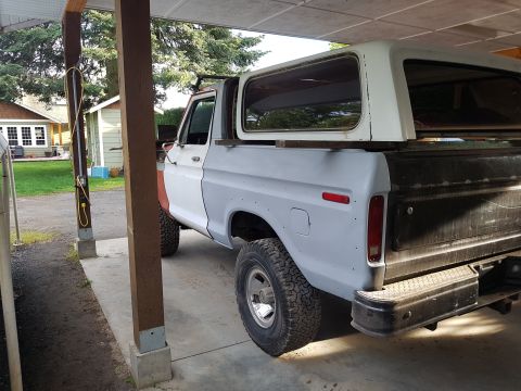 1978 Ford Bronco - The rear passenger side of a vintage Ford pickup truck, possibly a Bronco, is shown parked under a covered carport. The truck is in primer…