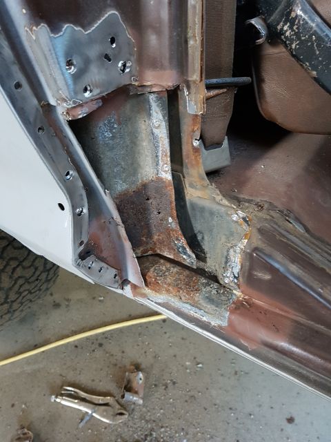 1978 Ford Bronco - This image shows the interior rocker panel area of a vehicle undergoing restoration. Significant rust damage is visible, along with evidenc…