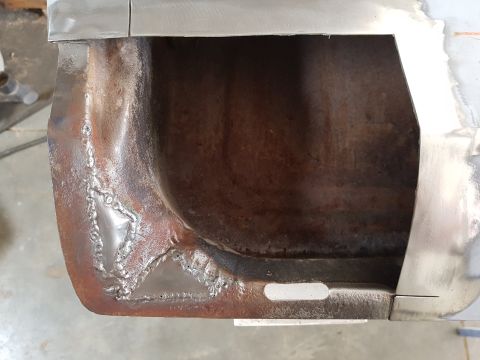 1978 Ford Bronco - This close-up shot shows the corner of a vehicle's body panel that has been repaired with welds. The metal appears to be rusty and has been…