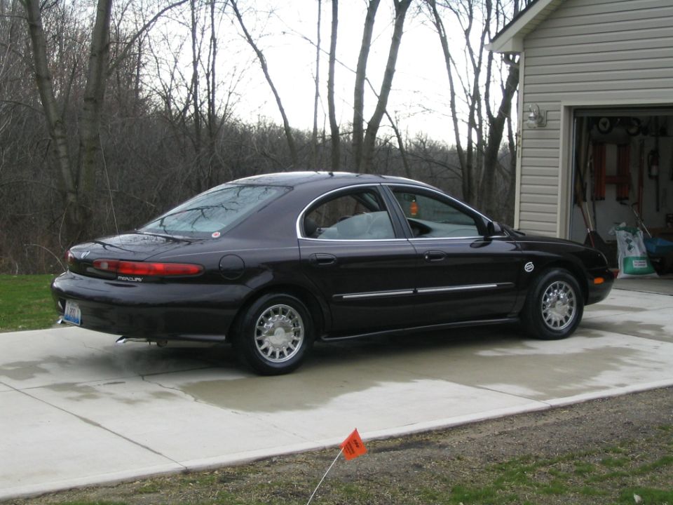 Dark plum Mercury Sable sedan parked in a driveway, rear three-quarter