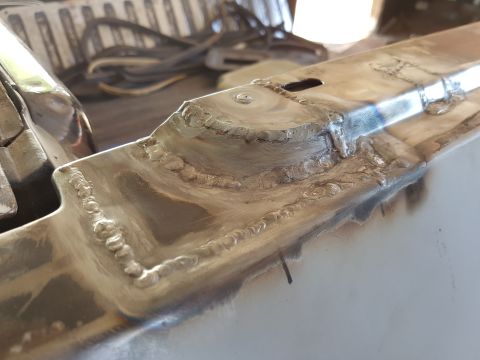 1978 Ford Bronco - Close-up view of freshly welded metal seams on what appears to be a vehicle frame or body panel. The welds are visible with some discolorat…