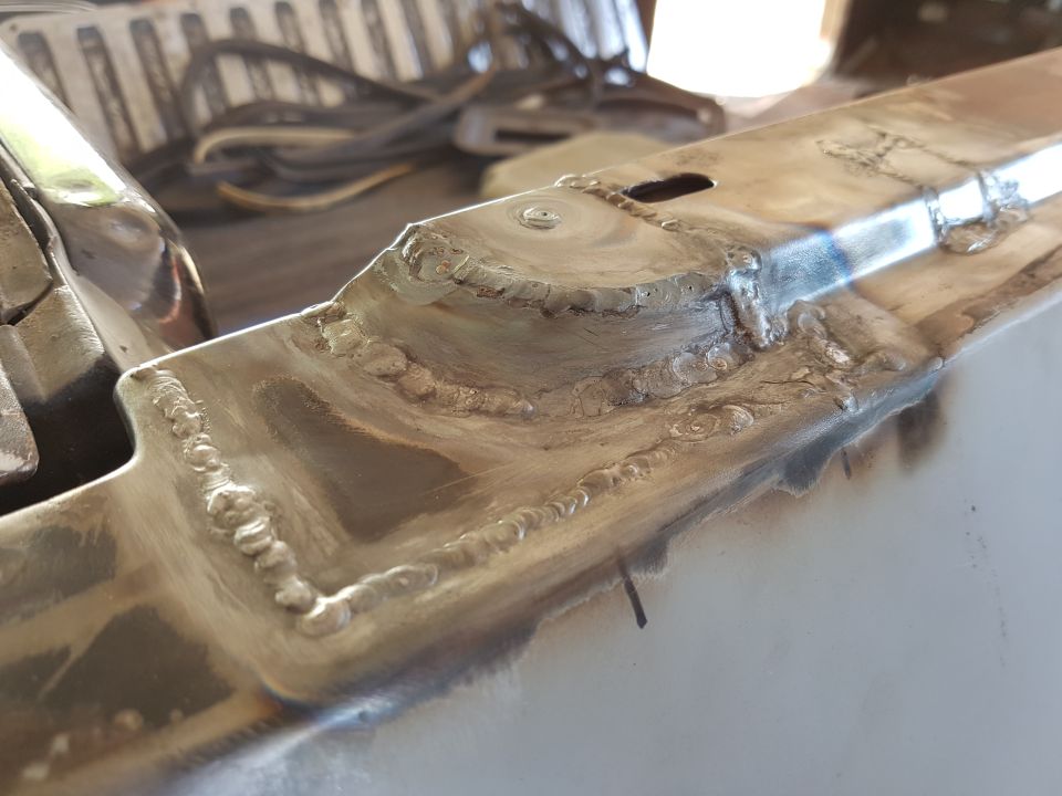 Close-up of welded metal seams on a vehicle part.