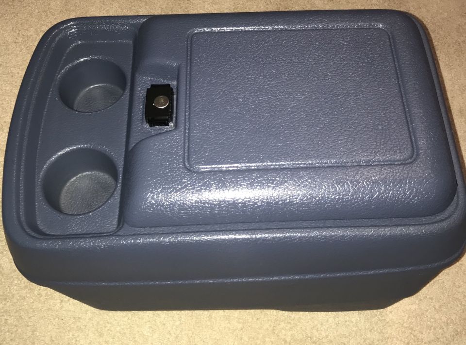 Dark blue plastic center console organizer with cup holders and latch.