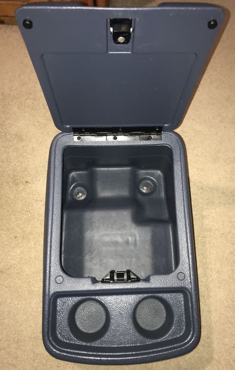 1995 Ford Bronco - This is an interior shot of an open dark blue center console with two cup holders at the bottom. The inside of the console shows two circul…