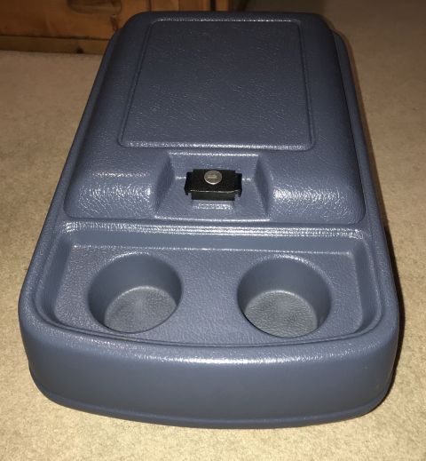 1995 Ford Bronco - A gray plastic center console with two cup holders and a small latch is shown from a top-down angle.