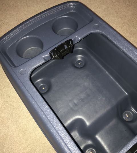 1995 Ford Bronco - A gray plastic center console storage compartment with two cup holders is shown from a top-down angle. The compartment is open, revealing t…