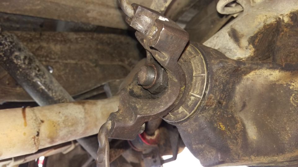 Close-up of rusty vehicle differential bracket and bolt underside