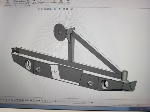 1978 Ford Bronco - A 3D CAD model of a custom rear bumper with an integrated spare tire carrier is displayed on a computer screen. The bumper features cutouts…