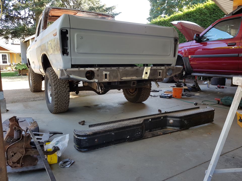 Rear view of a gray 1978 Ford Bronco undergoing modifications with a custom bumper.