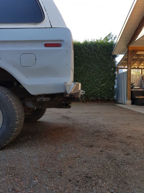 1978 Ford Bronco - Rear view of a 1978 Ford Bronco in primer, showing the quarter panel and hitch receiver.