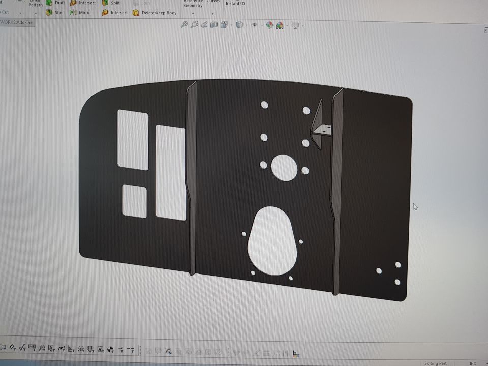 SolidWorks 3D CAD model of a flat sheet-metal bracket panel with cut holes