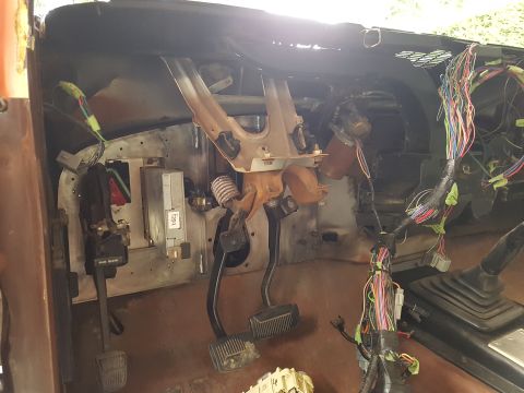 1978 Ford Bronco - The interior of a vehicle shows exposed wiring and pedals, suggesting a project or repair in progress.