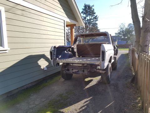 1978 Ford Bronco - This Ford Bronco has been converted into a pickup truck and is parked outside a residential building.