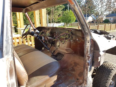 1978 Ford Bronco - The interior of a heavily modified vehicle shows exposed wiring and a worn seat, indicating extensive restoration work.