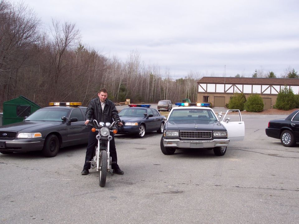 Front view of a 2001 Ford Crown Victoria police car with lights on