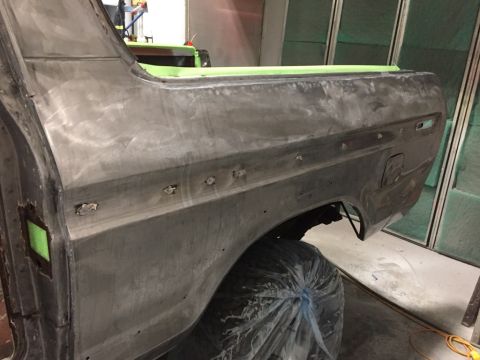 1978 Ford Bronco - The rear quarter panel of a 1978 Ford Bronco is shown during bodywork, with green tape protecting the edges.