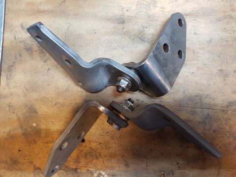 1978 Ford Bronco - These metal door hinges are shown on a wooden surface, with visible bolts and nuts.