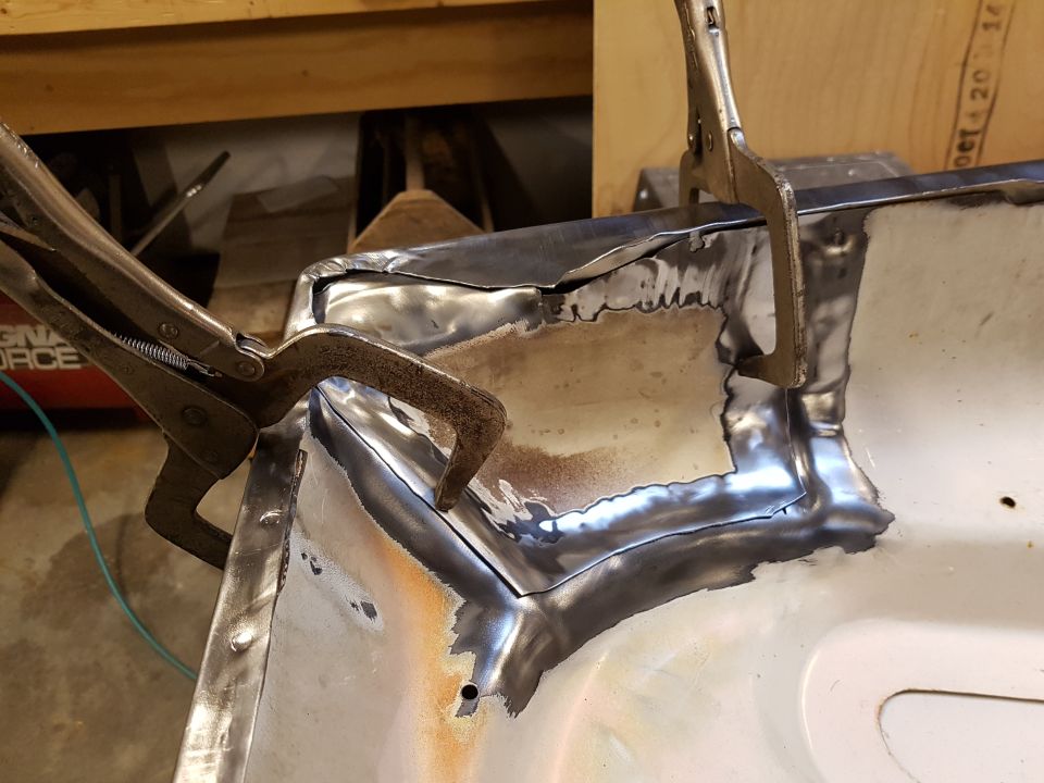 Clamped metal panel being welded, likely part of a vehicle body repair