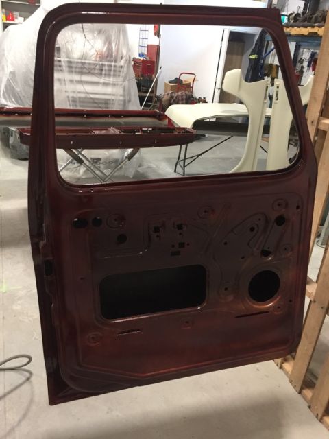 1978 Ford Bronco - A car door is shown in a workshop, possibly undergoing restoration or repair.