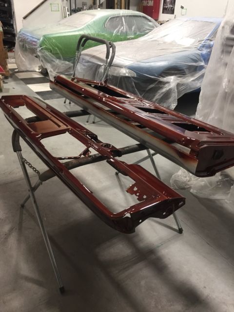 1978 Ford Bronco - Two car doors are undergoing restoration in a workshop, with other vehicles covered in plastic sheeting.