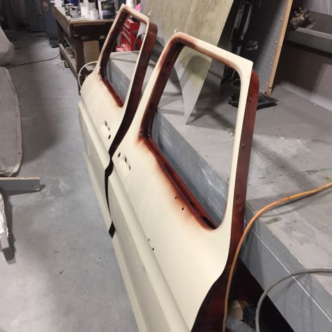 1978 Ford Bronco - Two car doors are shown in a workshop, undergoing preparation for painting.