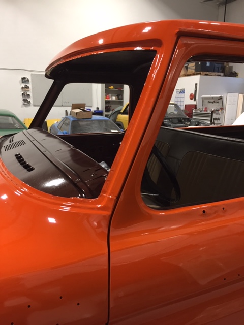 1978 Ford Bronco - An orange truck cab is shown from the side, with a view into the interior and dashboard area.