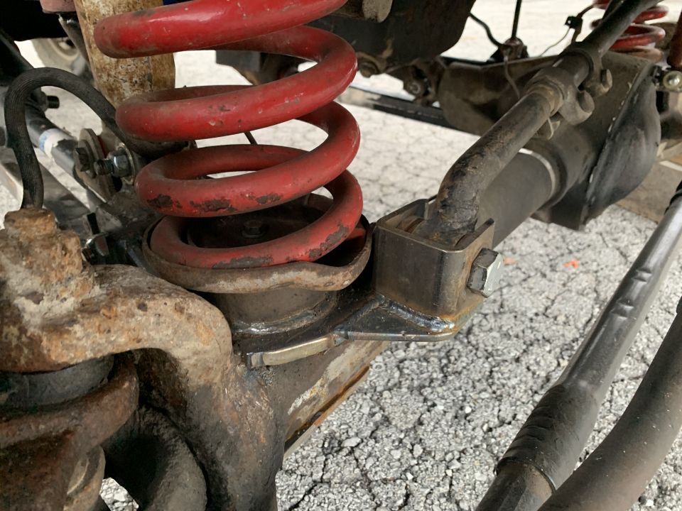Close-up of a red coil spring and suspension components on a vehicle