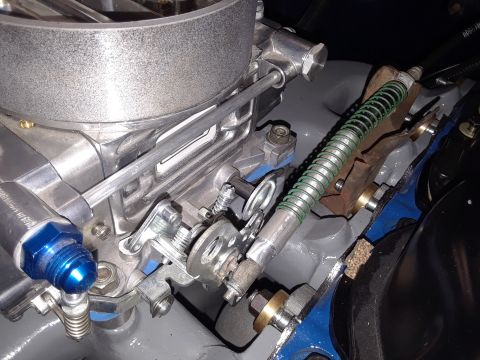 1985 Ford Bronco - Engine bay detail showing carburetor, throttle linkage, and fuel line assembly.
