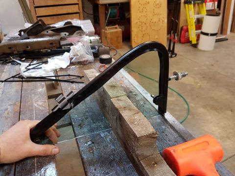 1978 Ford Bronco - A car door window frame and glass are on a workbench, with tools and parts in the background.