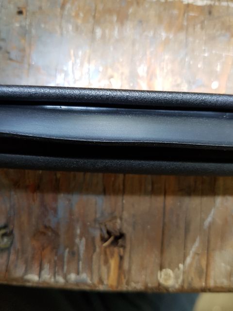 1978 Ford Bronco - A black rubber seal is shown against a weathered wooden background, with a website address visible at the bottom.