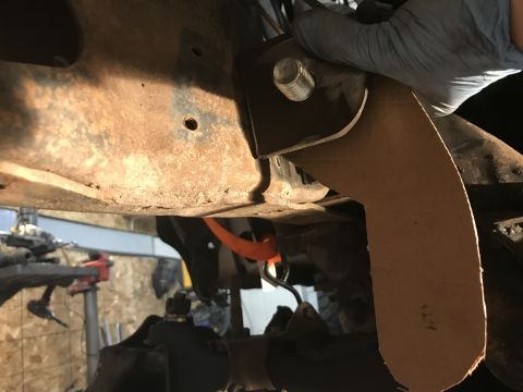 1984 Ford Bronco - Mechanic working on vehicle suspension components, showing rusty frame and new bracket.