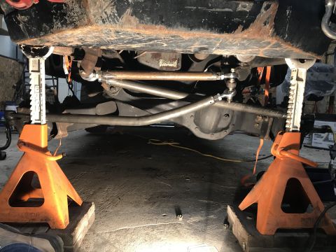1984 Ford Bronco - Plumbing kit laid out on carpet including an aluminum fuel cell, red fuel rails, fittings and braided stainless steel lines.