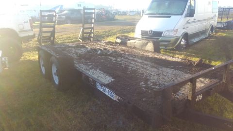1990 Ford F-250 - A trailer is covered in mud, with a white Mercedes-Benz Sprinter van visible behind it in a grassy area.