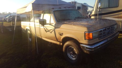 1990 Ford F-250 - 1990 Ford F-250 pickup truck parked under a canopy at an outdoor event.