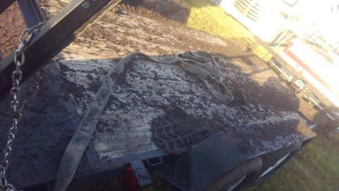 1990 Ford F-250 - A trailer bed is covered in mud and a strap, with the Supermotors.net logo in the corner.