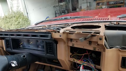 1985 Ford Bronco - The dashboard of a vehicle is partially disassembled, revealing wiring and instrumentation.