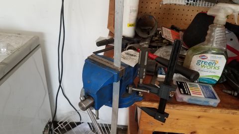 1985 Ford Bronco - A workbench scene a blue vise, caliper, and a bottle of Green Works cleaner.