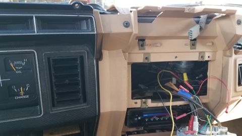 1985 Ford Bronco - The dashboard of a vehicle shows exposed wiring and gauges, indicating an aftermarket installation or repair.
