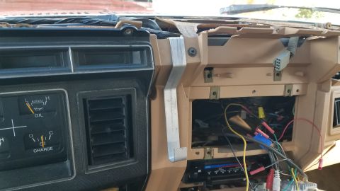 1985 Ford Bronco - The dashboard of a vehicle shows exposed wiring and an oil gauge, suggesting an older model.