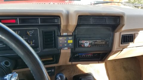 1985 Ford Bronco - The dashboard of a truck features an aftermarket digital gauge cluster and a Pioneer stereo system.