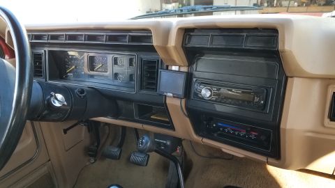 1985 Ford Bronco - Interior view of a 1980s Ford truck dashboard, showing the instrument cluster and aftermarket audio equipment.