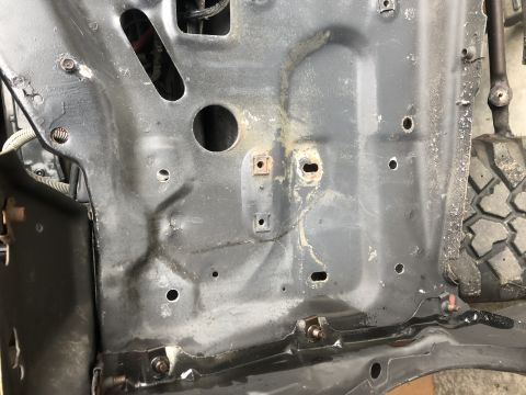 1978 Ford Bronco - Close-up view of the inner fender well structure, revealing mounting points and wiring harnesses.