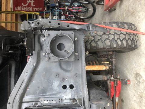 1978 Ford Bronco - Close-up of a vehicle's front chassis and suspension components, including a tire and shock absorbers.