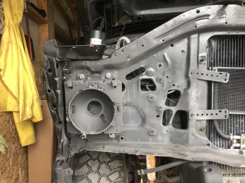 1978 Ford Bronco - The front end structure of a vehicle, showing the headlight bucket and radiator assembly, is visible.