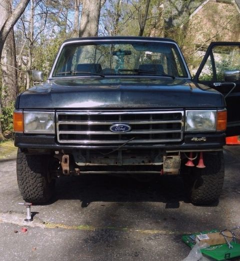1988 Ford Bronco - This Ford truck, likely from the late 1980s, is parked outdoors with its front end exposed and bumper removed.